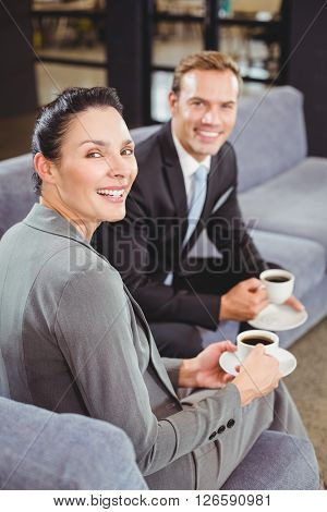 Portrait of businessman and businesswoman having tea during breaktime in office