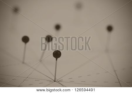 Black Pins In Paper Linked By Lines