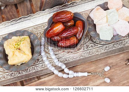 Turkish delights with tasbih on silver oriental tray, top view