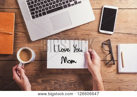 I love you mom sign. Office desk. Mothers day composition. Studio shot on wooden background.