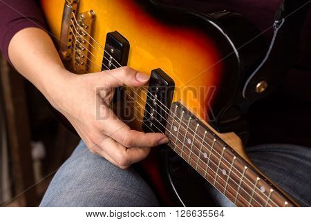 Woman's hands playing electric guitar close up focus right hand
