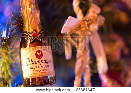 Champagne toy bottle hanging on christmas tree and lights
