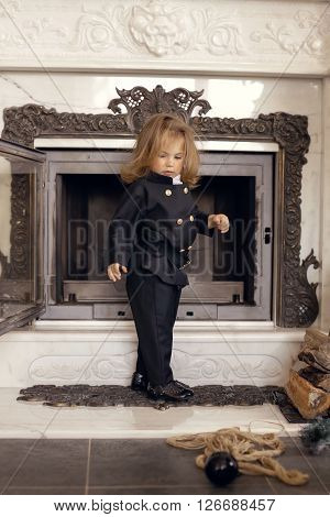Girl as a chimney sweep against fireplace. Lucky New Year's Eve and New Year.
