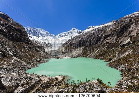Llaca lagoon (4474 m) in the peruvian Andes and Ocshapalpa peak (5888 m) and Ranrapalca peak (6162 m), Peru.