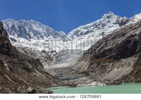 Llaca lagoon (4474 m) in the peruvian Andes and Ocshapalpa peak (5888 m) and Ranrapalca peak (6162 m), Peru.