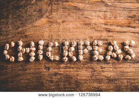chickpeas written with chickpeas on wood background