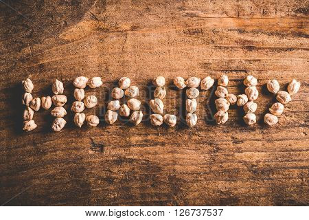 healthy written with chickpeas on wood background