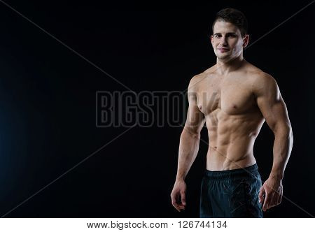 Man showing his six pack abs on black background