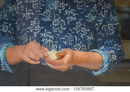Closeup of hands making Chinese steamed bun