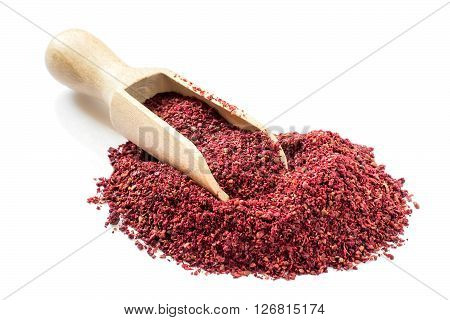 Popular eastern spice sumac in a scoop on a white background