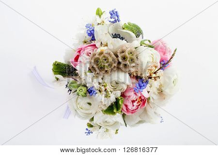 Bouquet from pink tulips violet grape hyacinths white anemones violet veronica and white buttercup with violet ribbon on white background from the top