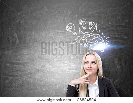 Brainstorming concept with happy businesswoman and lightbulb and brain sketch on concrete wall. Mock up