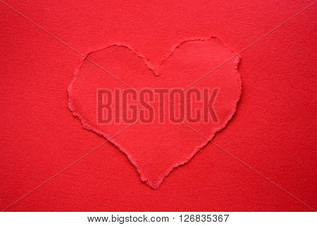 Red torn paper heart on red paper