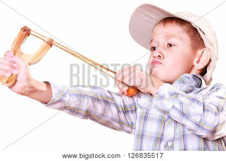 Nature and free time prankster little boy. Child have fun with wooden sling shot and fruit aim mandarine.