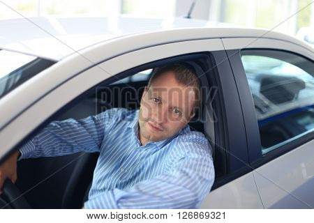 Handsome man in his new white car