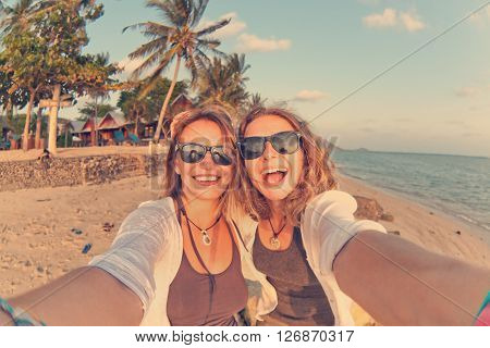 Two Happy Girlfriends Making Selfie On The Coast Of Tropical Sea