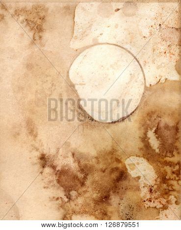 An abstract old paper texture: a sheet of paper toned and painted to look like old parchment with a ring from a coffee or tea cup with a place for text or logo