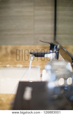 water running from faucet in hotel washroom