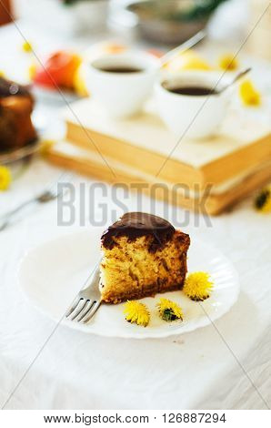 Traditional homemade chocolate cake. Rustic style and natural light. Chocolate Mud Cake on White table. Piece of chocolate cake with icing. Vanilla Cake with Chocolate Glaze.