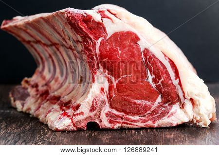Fresh Raw Beef bone rib roughly choppid on wooden table.