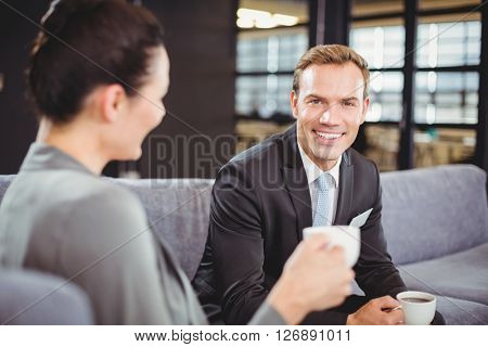 Businessman and businesswoman having a discussion during breaktime in office