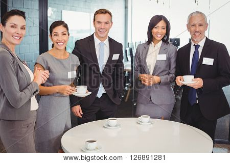 Portrait of businesspeople having tea during breaktime in office