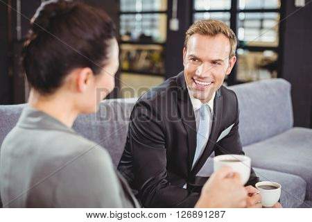 Businessman and businesswoman having a discussion during breaktime in office