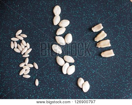 seeds of three types of vegetable cultures against a dark background