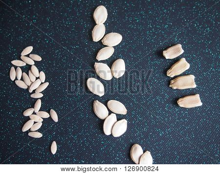 seeds of three types of vegetable cultures against a dark background