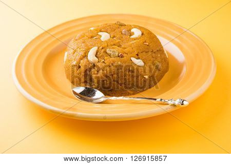 Moong Dal Halwa - a sweet dish from India, Indan Sweet Halwa made from Moong Dal, moong dal sweet sheera or shira cooked in pure ghee, served in a yellow ceramic plate