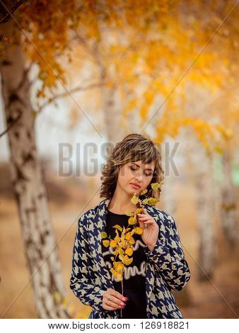 Portrait of beautiful woman, on background autumn park