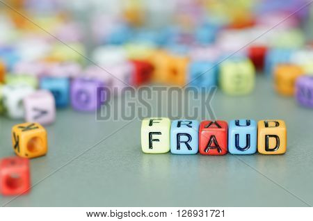 Close up of Fraud word on colorful dices