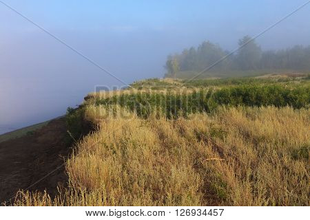Mysterious Volga riverside in fog. Misty dawn early morning nature grassland landscape view in Russian countryside.
** Note: Visible grain at 100%, best at smaller sizes