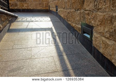 Embedded in the granite pavement lights. Lighting of the sidewalk.