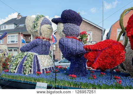 HILLEGOM, THE NETHERLANDS - APRIL 23, 2016: Moving platform with a huge frame made in a form of a traditional Dutch kissing couple. Taking part in the  traditional flowers parade 