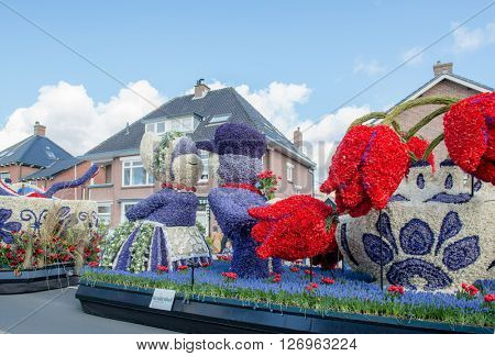 HILLEGOM, THE NETHERLANDS - APRIL 23, 2016: Moving platform with a frame made in a form of a traditional Dutch kissing couple and tulips. Taking part in the  traditional flowers parade 