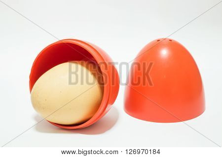 Red plastic egg on white table stock photo
