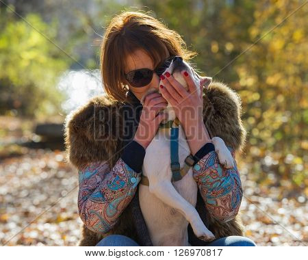 portrait of a woman with a dog on holiday in the autumn park  age of 40 years
