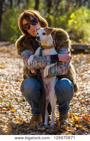 portrait of a woman with a dog on holiday in the autumn park  age of 40 years
