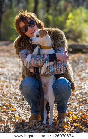 portrait of a woman with a dog on holiday in the autumn park  age of 40 years