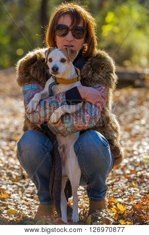 portrait of a woman with a dog on holiday in the autumn park  age of 40 years