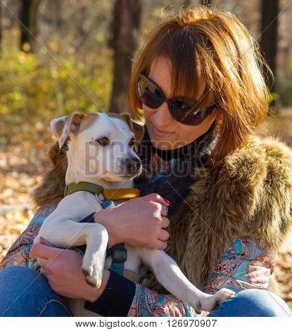 portrait of a woman with a dog on holiday in the autumn park  age of 40 years