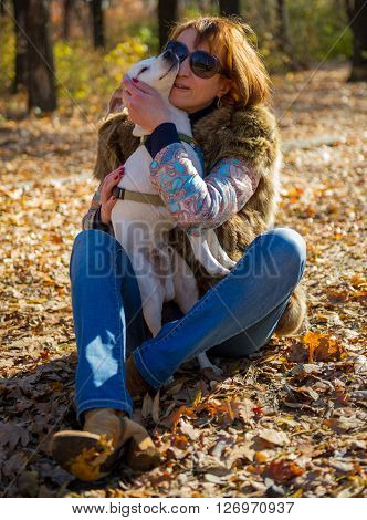 portrait of a woman with a dog on holiday in the autumn park  age of 40 years