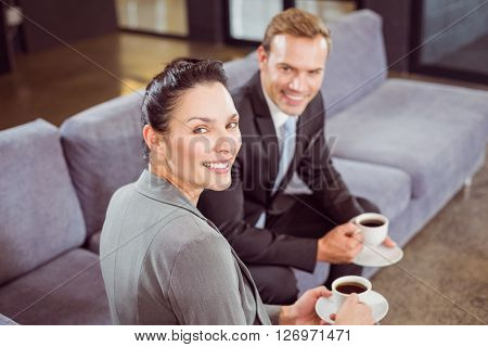 Portrait of businessman and businesswoman having tea during breaktime in office