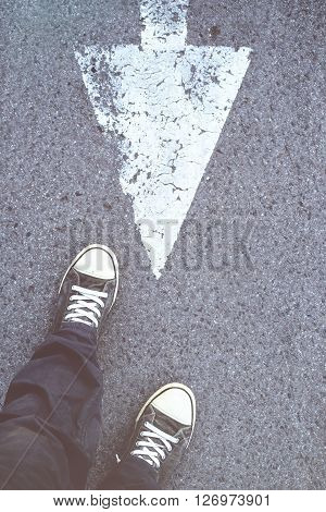 Young rebellion male going against the mainstream man standing on the street and making a step in opposite direction.