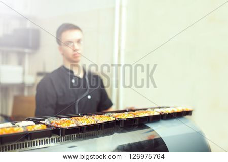 male cooks preparing sushi in the restaurant kitchen.