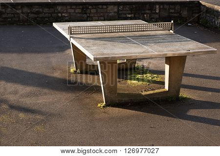 robust outdoor ping pong table from concrete with a network of metal on an asphalt area copy space