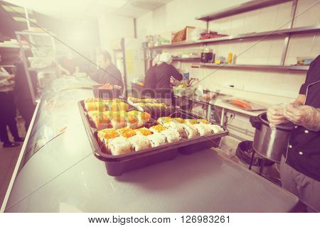 male cooks preparing sushi in the restaurant kitchen.