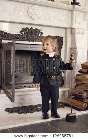 Girl as a chimney sweep against fireplace. Lucky New Year's Eve and New Year.