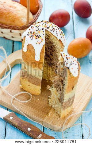 Layered Chocolate Easter Cake Kulich Or Paska Cut On Dining Table With Colored Easter Eggs